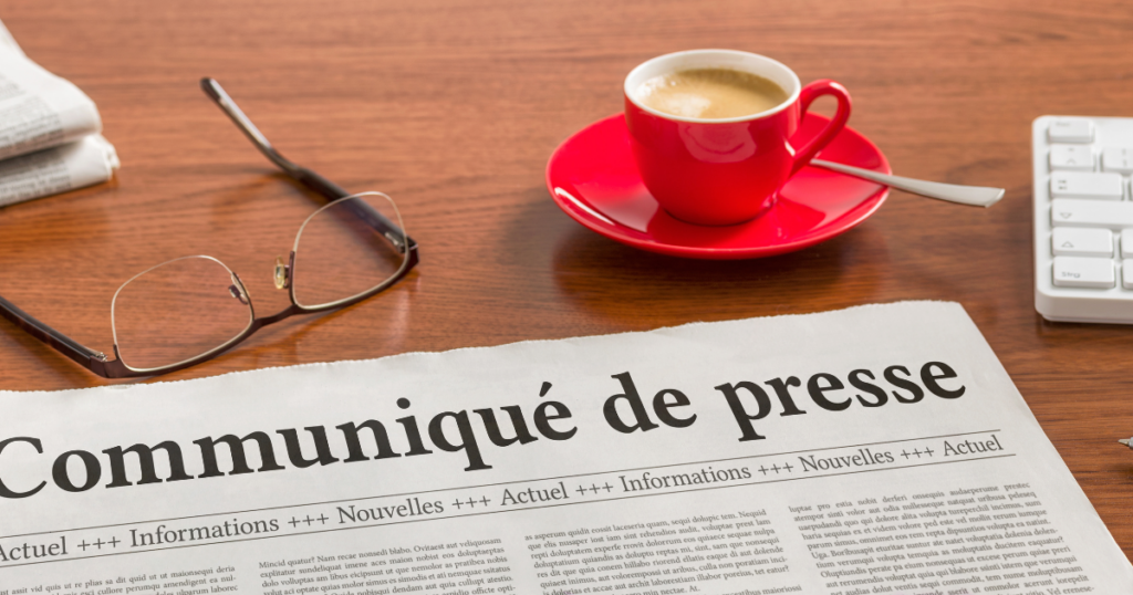 newspaper on table with coffee cup, glasses and part of a keyboard
